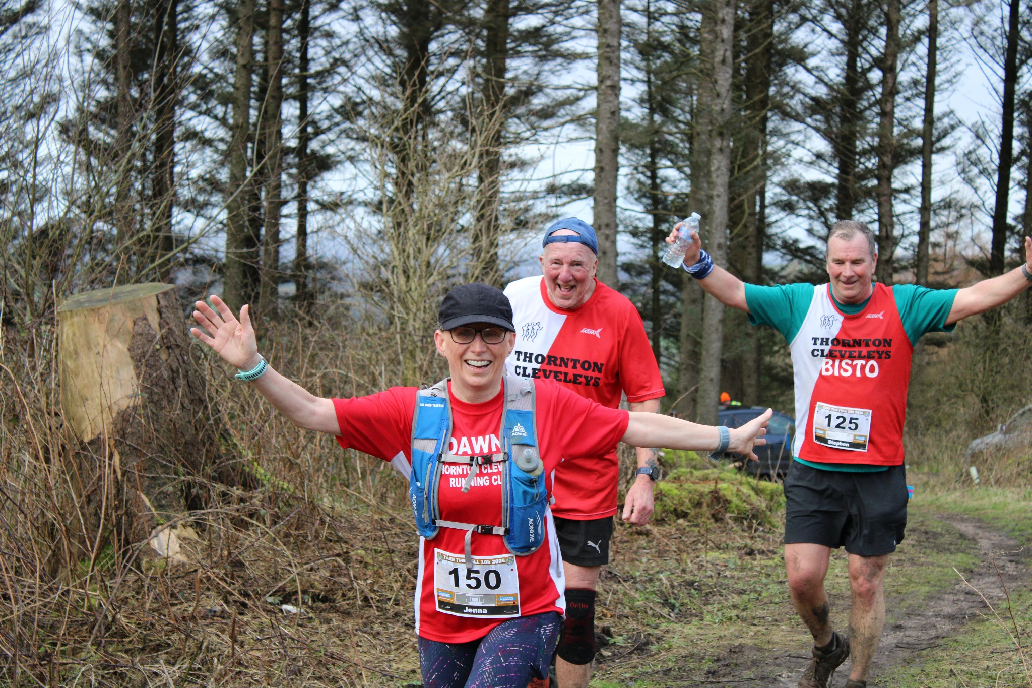Smiling Take the Fell runners on a woodland path